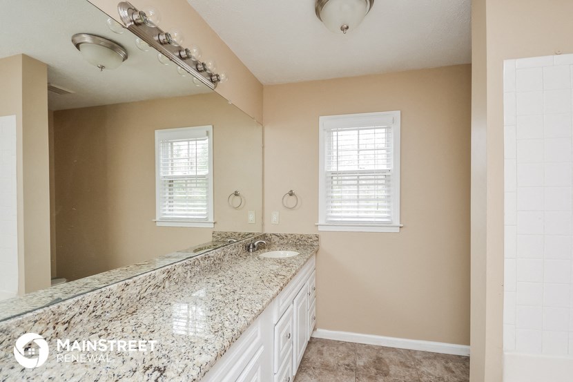 a bathroom with a large mirror and a granite counter top