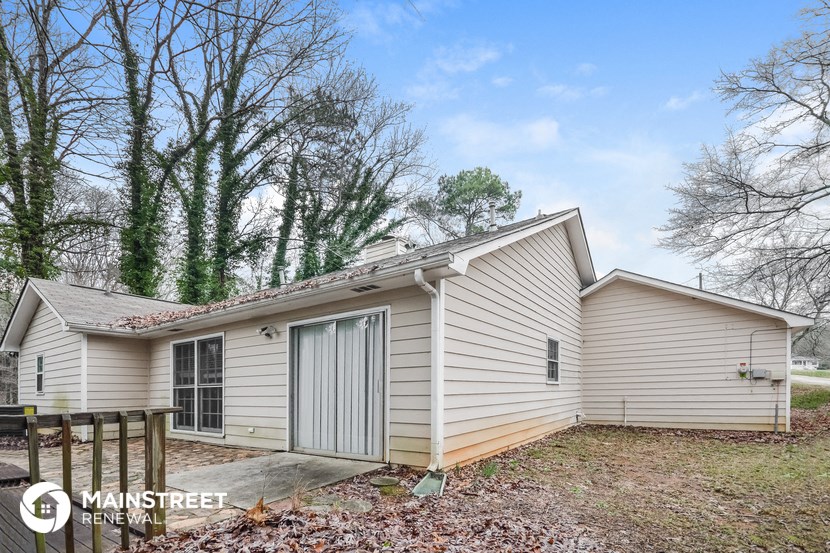 the exterior of a small white house with a garage