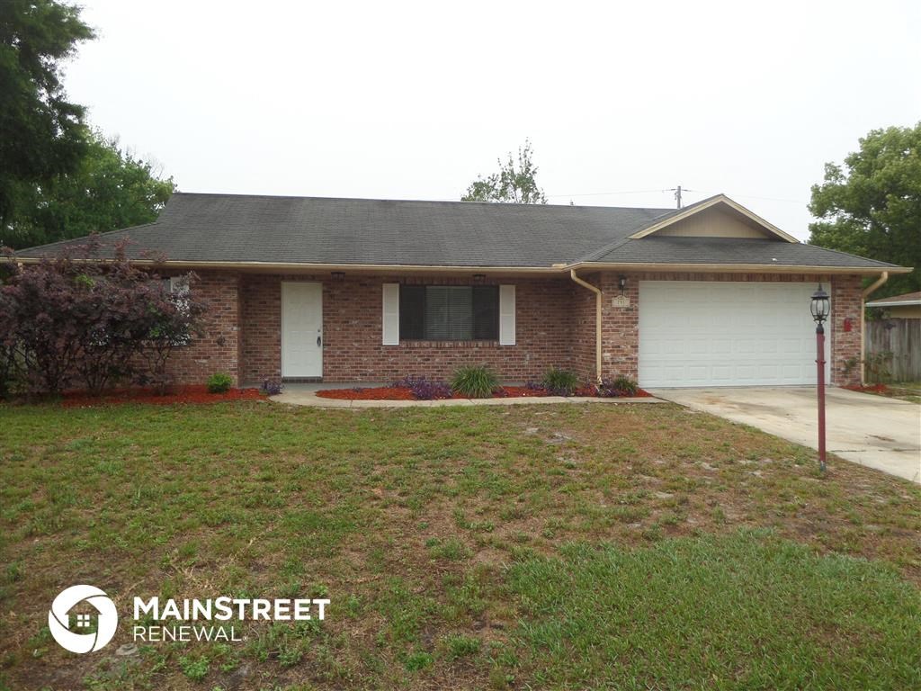 a small brick house with a lawn in front of it