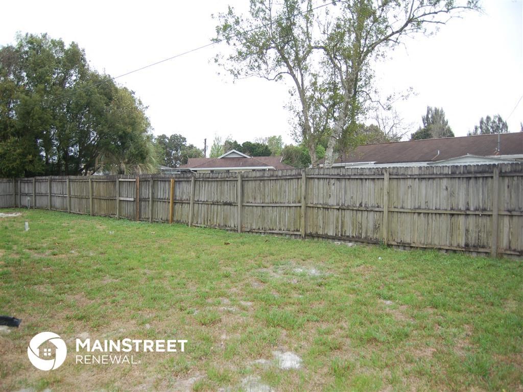 the backyard of a home with a wooden fence