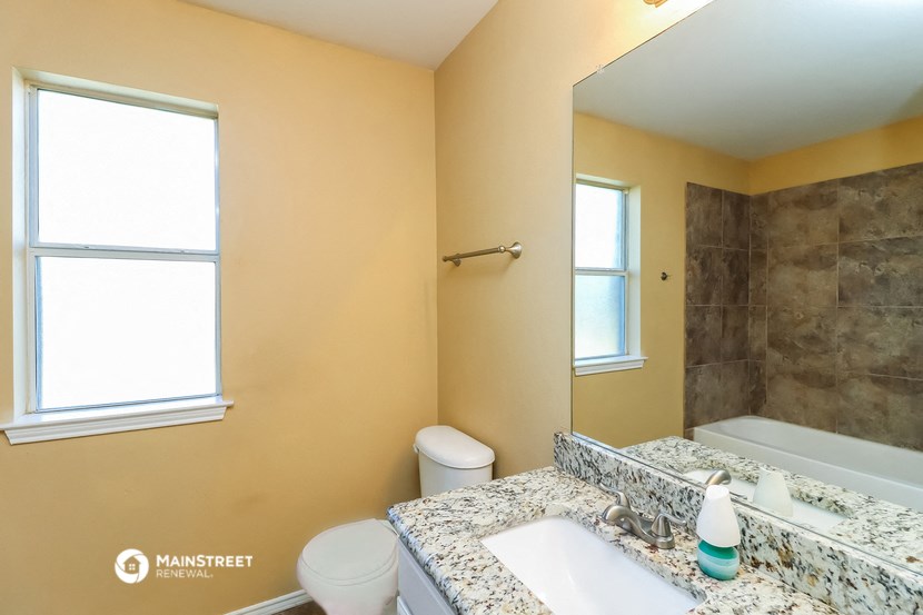 a bathroom with a sink toilet and tub and a mirror