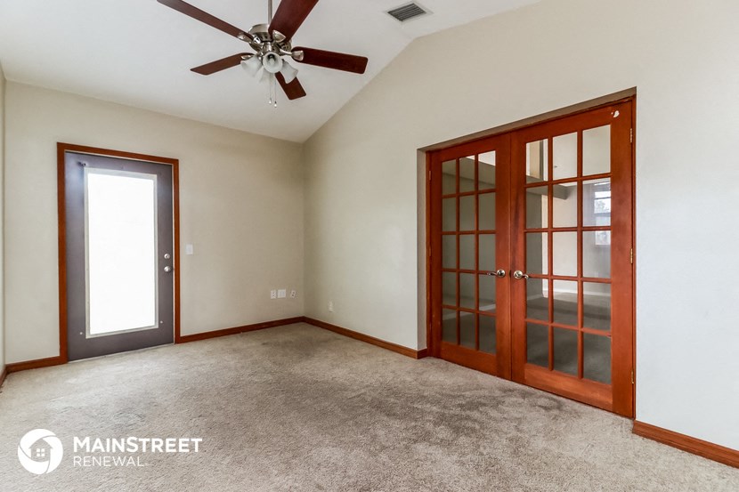 a living room with carpet and a ceiling fan