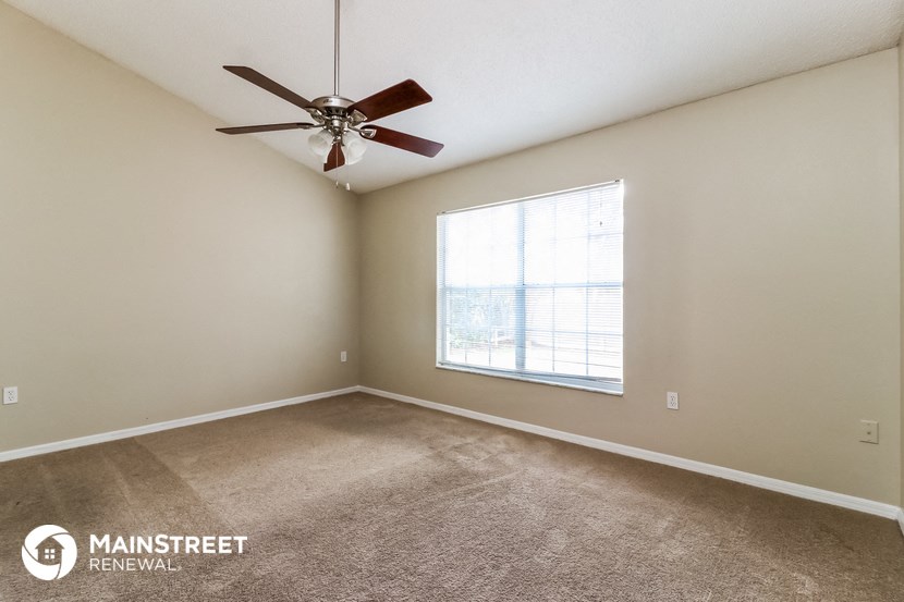 a living room with a ceiling fan and a window