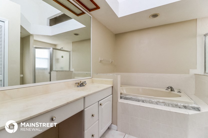 a bathroom with a tub and a sink and a mirror