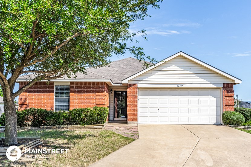 a small brick house with a white garage door