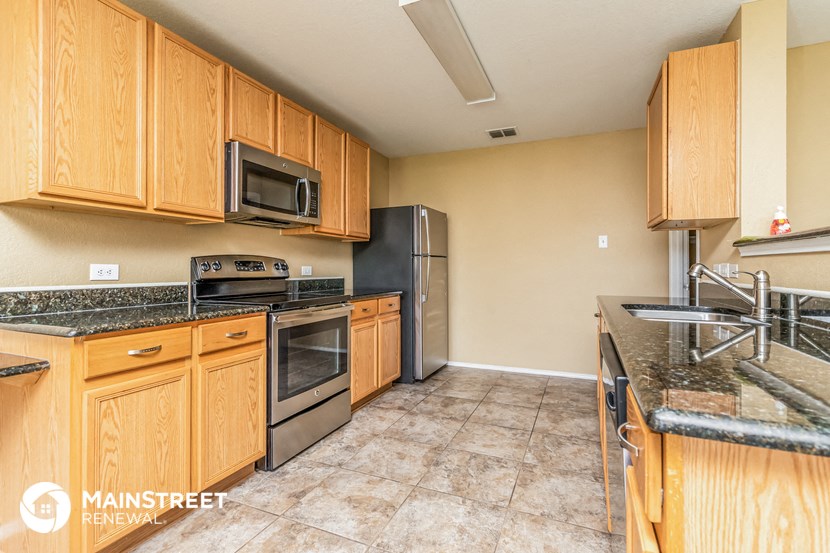 a kitchen with wooden cabinets and stainless steel appliances