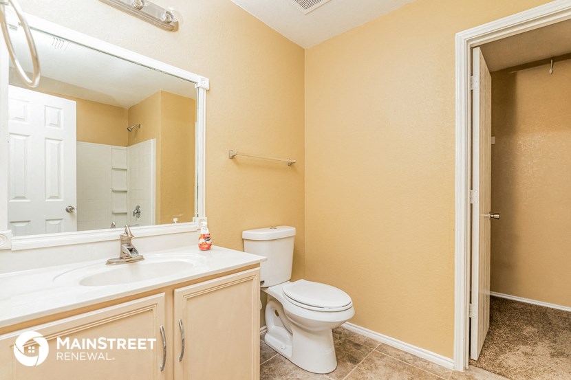 a bathroom with a toilet and a sink and a mirror