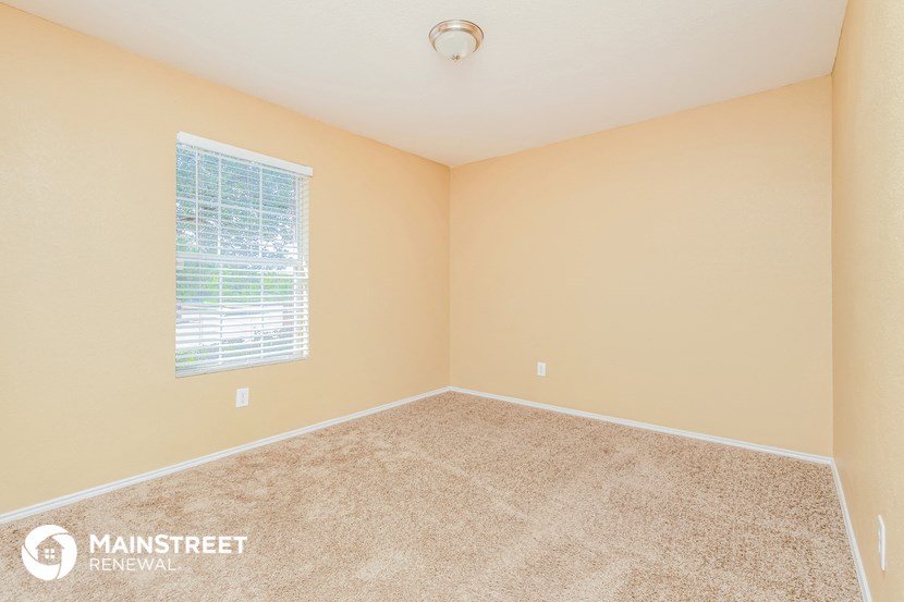 an empty room with carpet and a window
