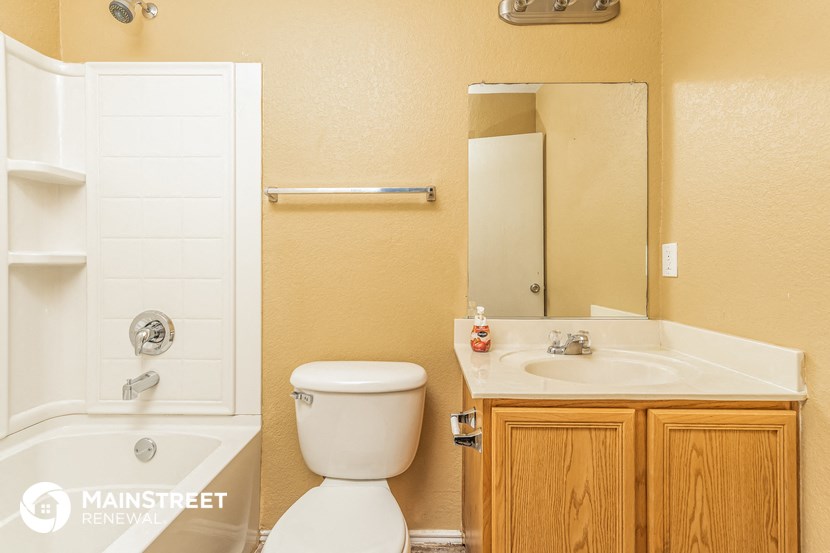 a bathroom with a toilet sink and tub and a mirror