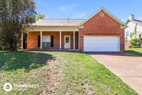 a brick house with a white garage door and a lawn