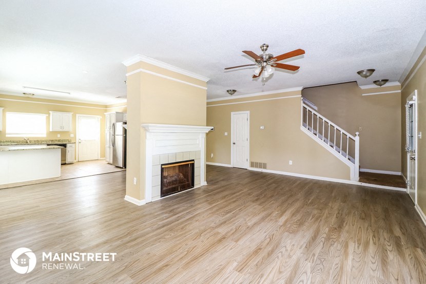 a living room with a fireplace and a ceiling fan