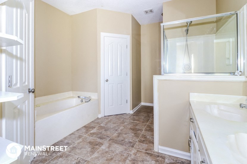 a bathroom with a tub and a sink and a mirror