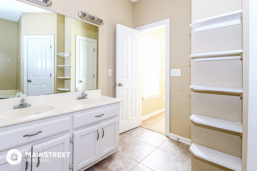a bathroom with a sink and a mirror and a closet