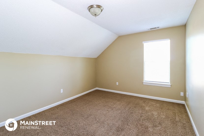 an empty room with carpet and a window