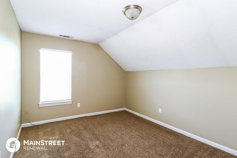 an empty room with carpet and a window