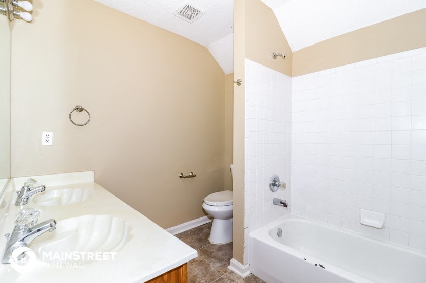 a bathroom with a tub and a sink and a toilet