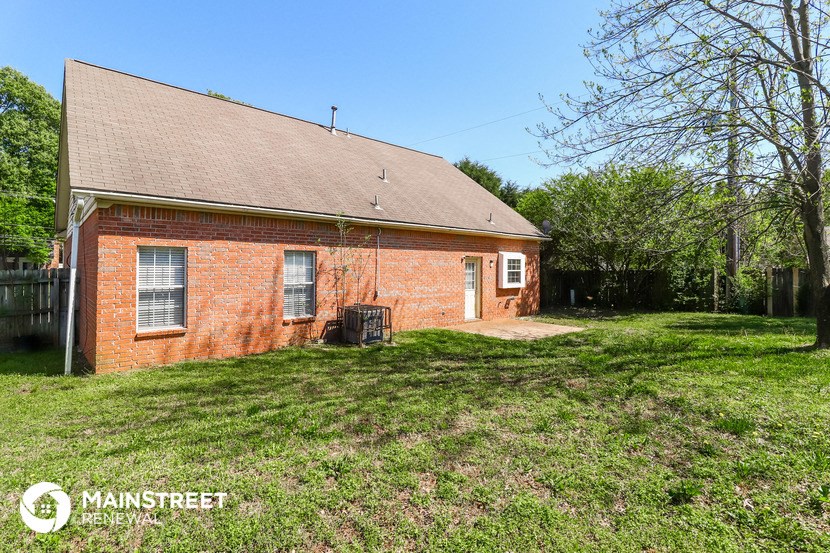 the front of a brick house with a grassy yard