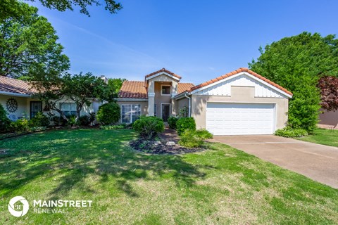 a home with a lawn and a white garage door