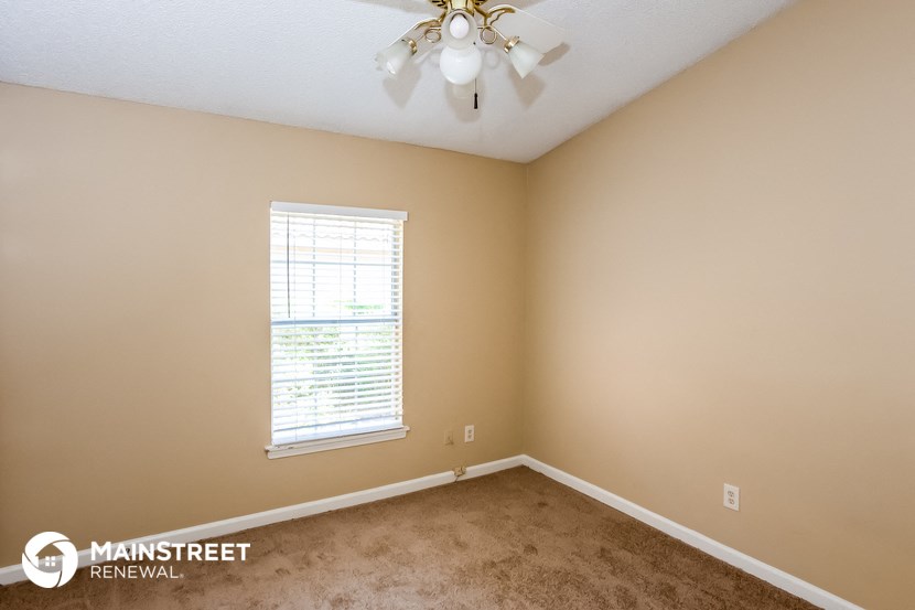 the upstairs bedroom with carpet and a ceiling fan