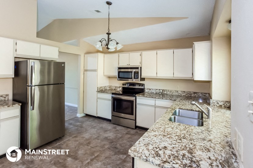 a large kitchen with granite counter tops and stainless steel appliances
