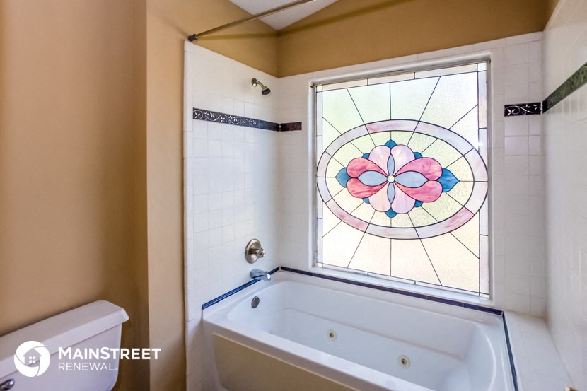 a bathroom with a tub and a stained glass window