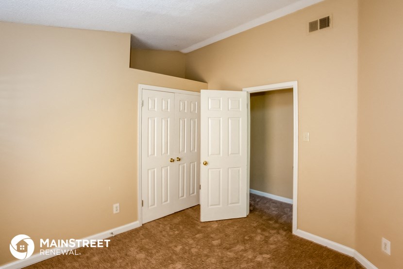 a bedroom with two doors and a closet