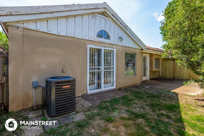 a side view of a house with a heater in the yard
