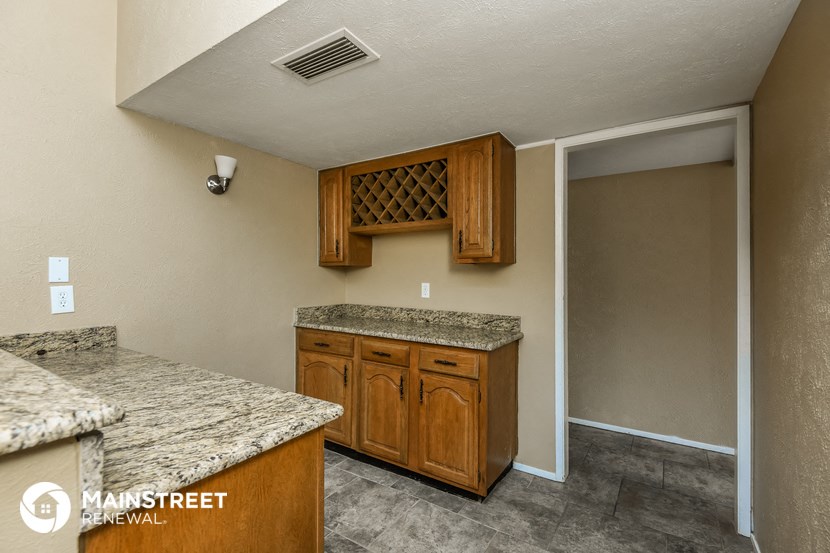 a kitchen with granite counter tops and wooden cabinets