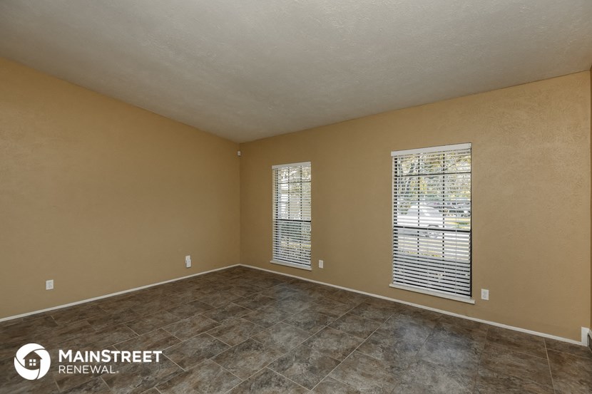 the spacious living room with tile flooring and large windows