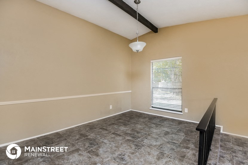 the living room of an empty home with a large window