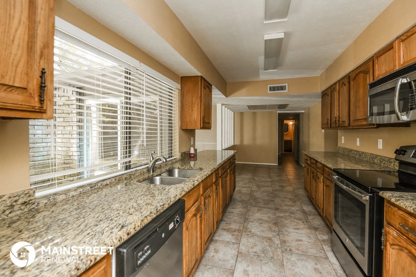 a kitchen with wood cabinets and granite counter tops and a sink