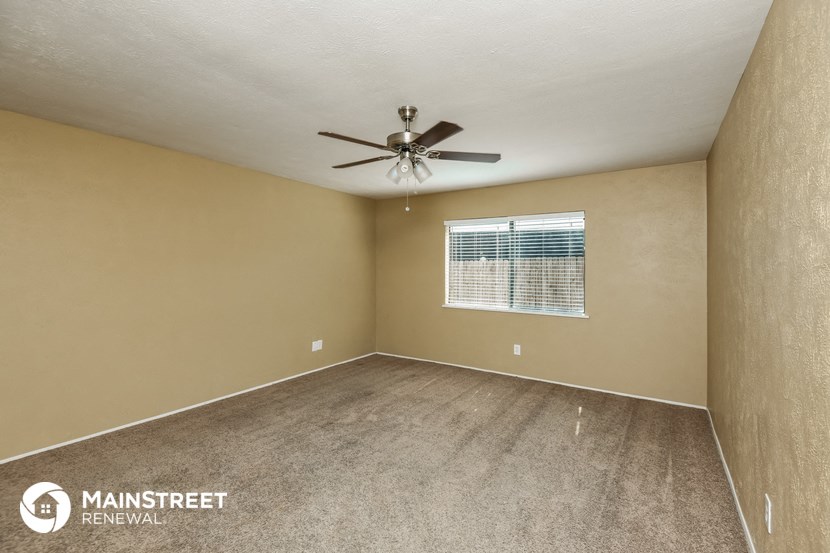 an empty room with a ceiling fan and a window