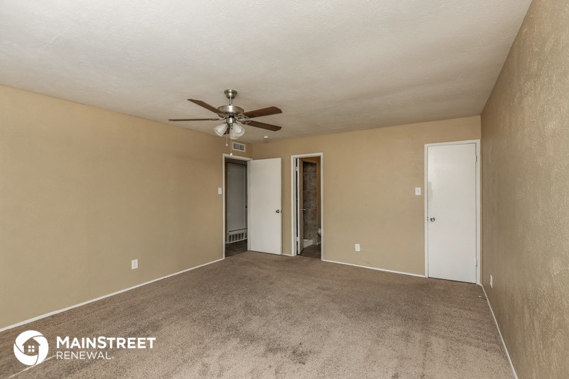 a living room with carpet and a ceiling fan