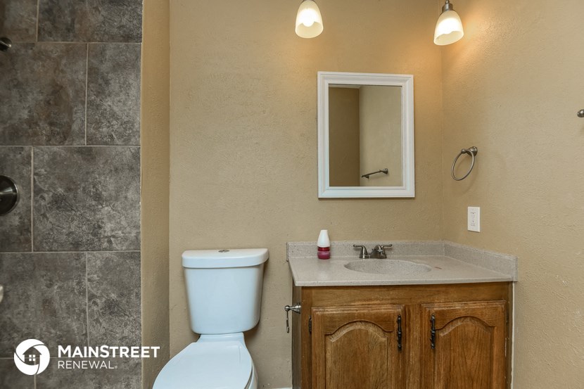 a bathroom with a toilet sink and a mirror