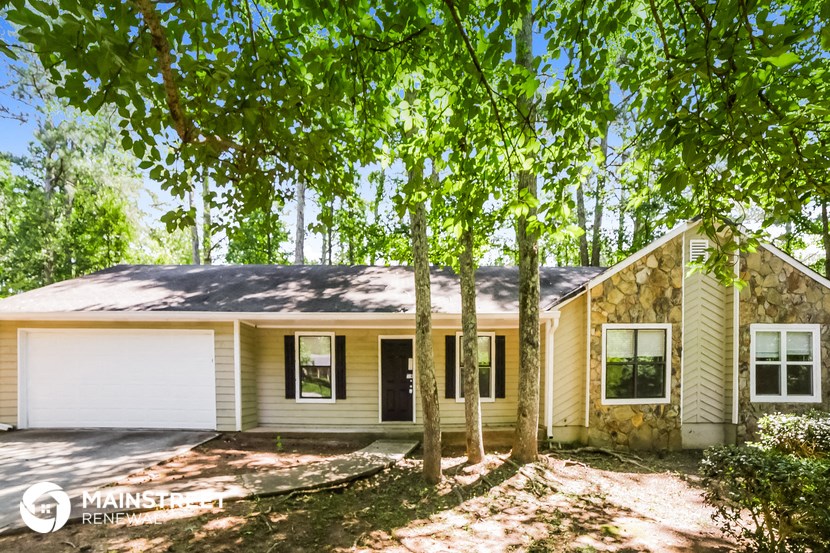a yellow and with trees in front of it