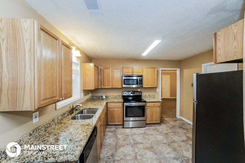 a kitchen with granite counter tops and wooden cabinets