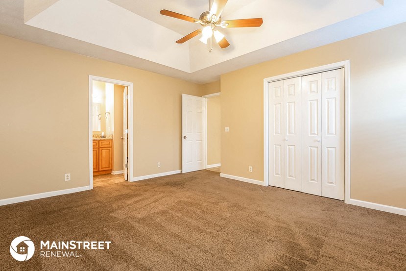 a living room with carpet and a ceiling fan