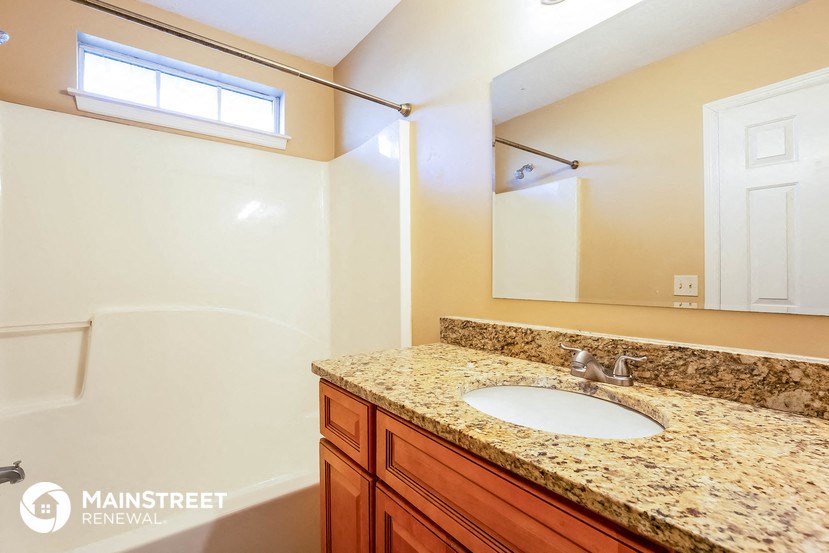 a bathroom with a sink and a shower and a mirror