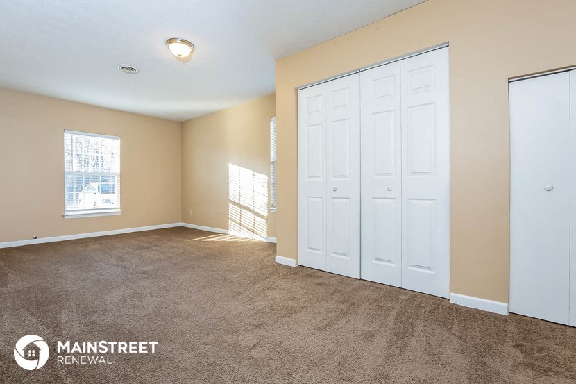 a bedroom with two closets and a carpeted floor