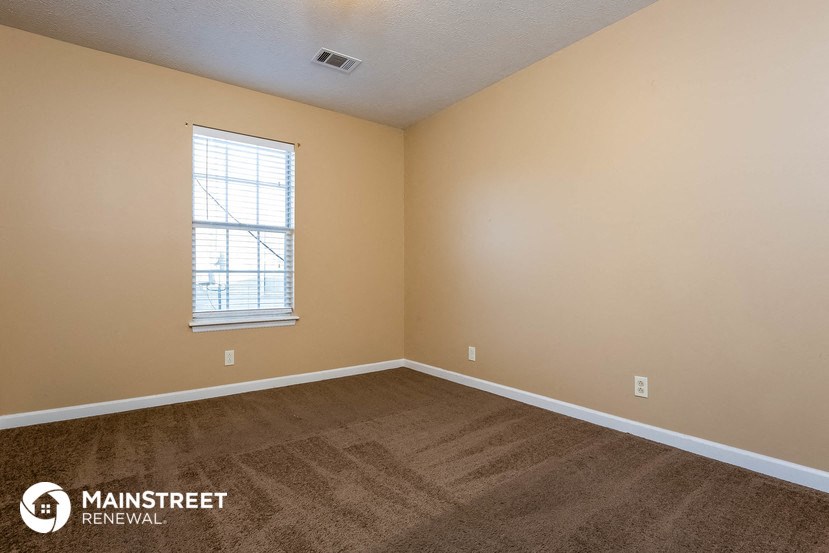 the living room of a home with carpet and a window