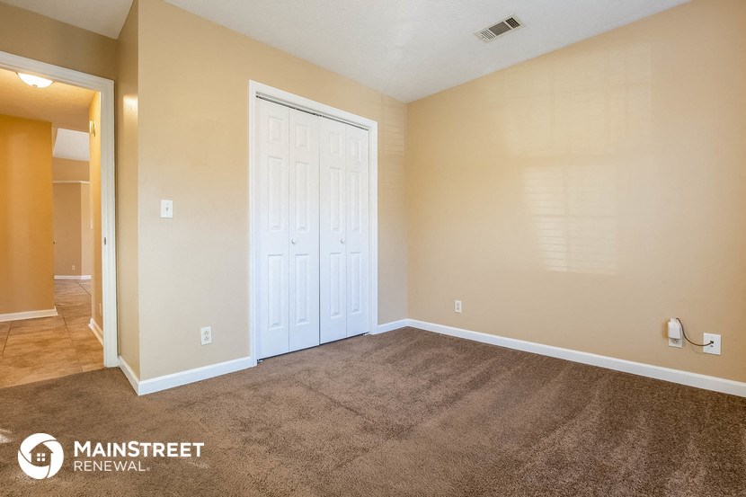 the living room of a home with carpet and a white door