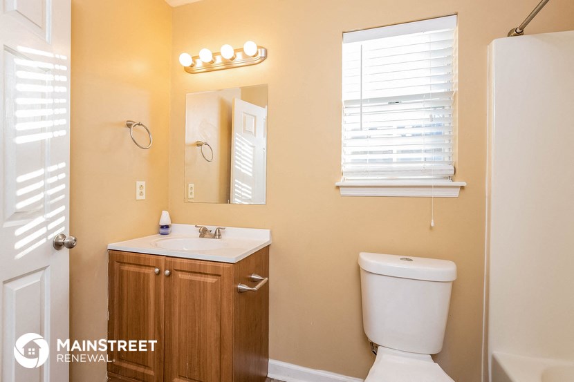 a bathroom with a toilet and a sink and a mirror