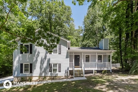 a white house with a porch and trees