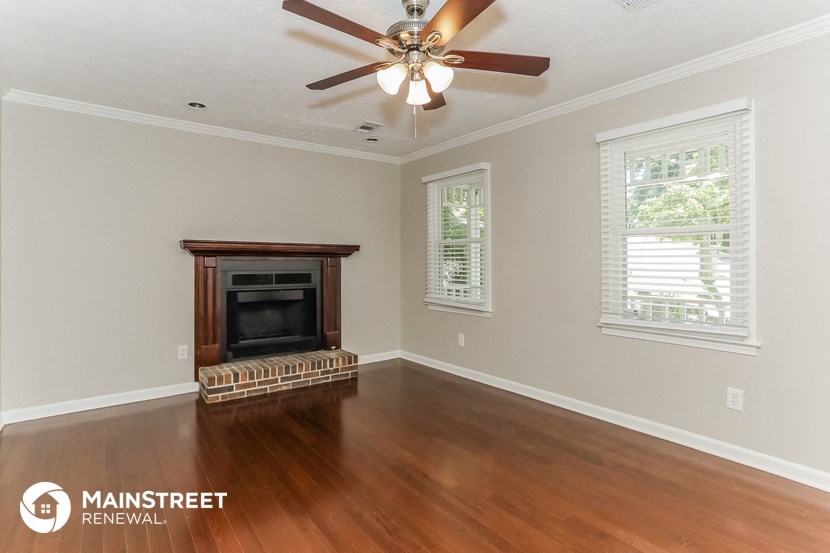 the living room with wood flooring and a fireplace