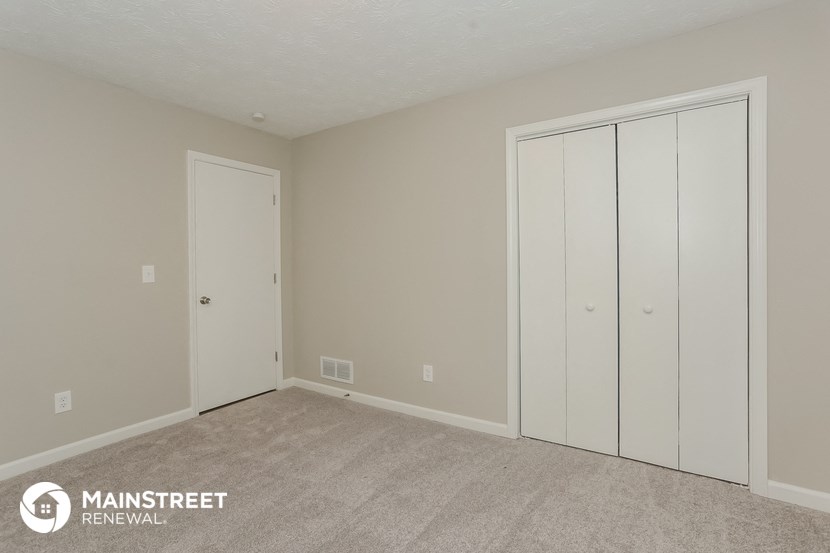 a bedroom with two closets and a carpeted floor