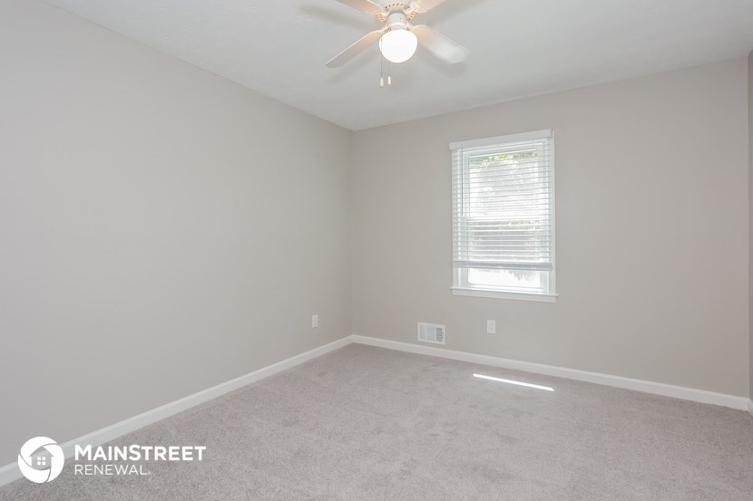 the upstairs bedroom with carpet and a ceiling fan