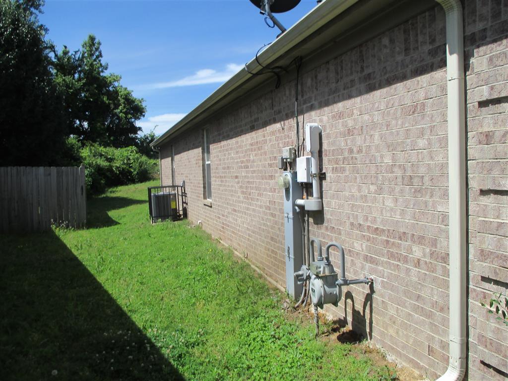 the side of a brick building with electricity meters on the side