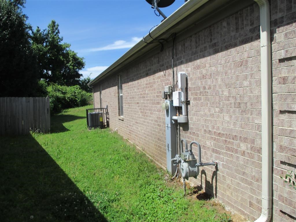 the side of a brick building with electricity meters on the side