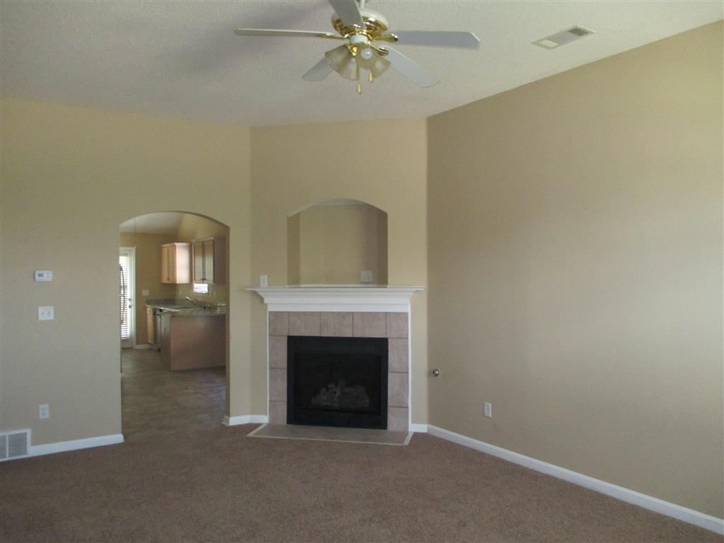 a living room with a fireplace and a ceiling fan