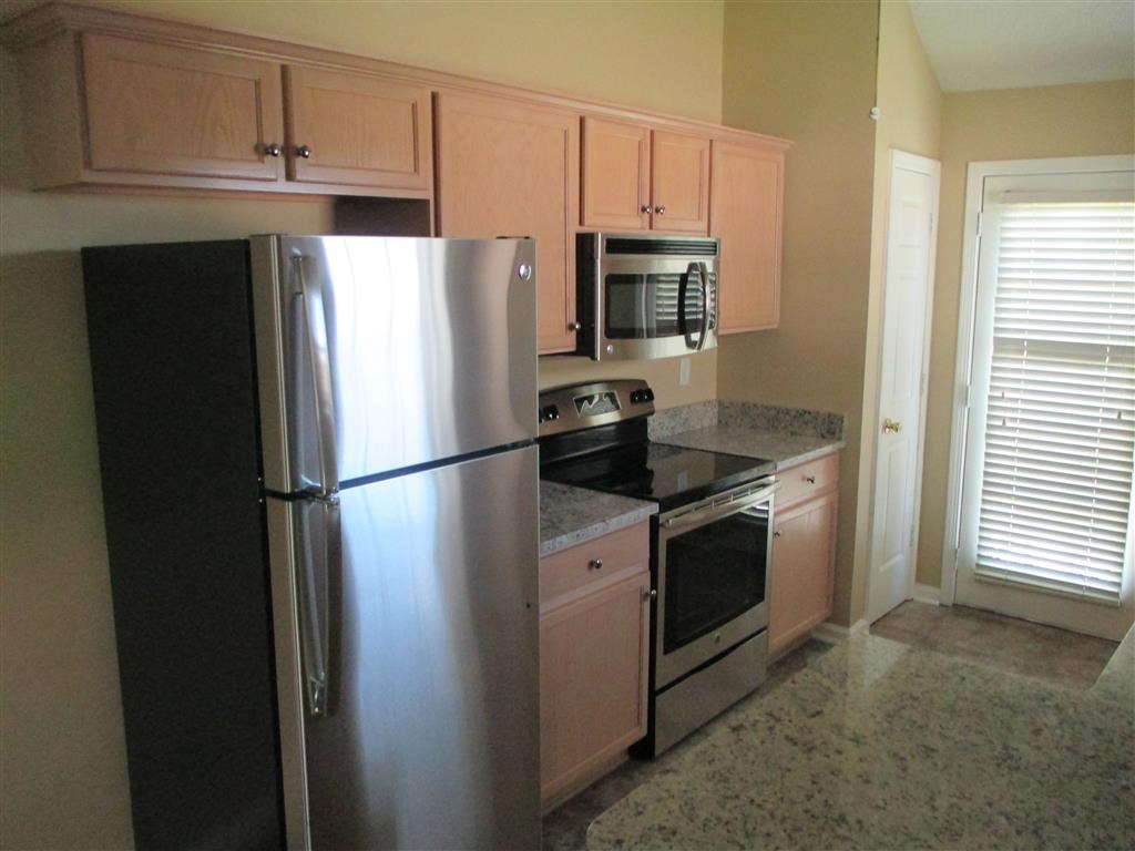 a kitchen with a stainless steel refrigerator and stove